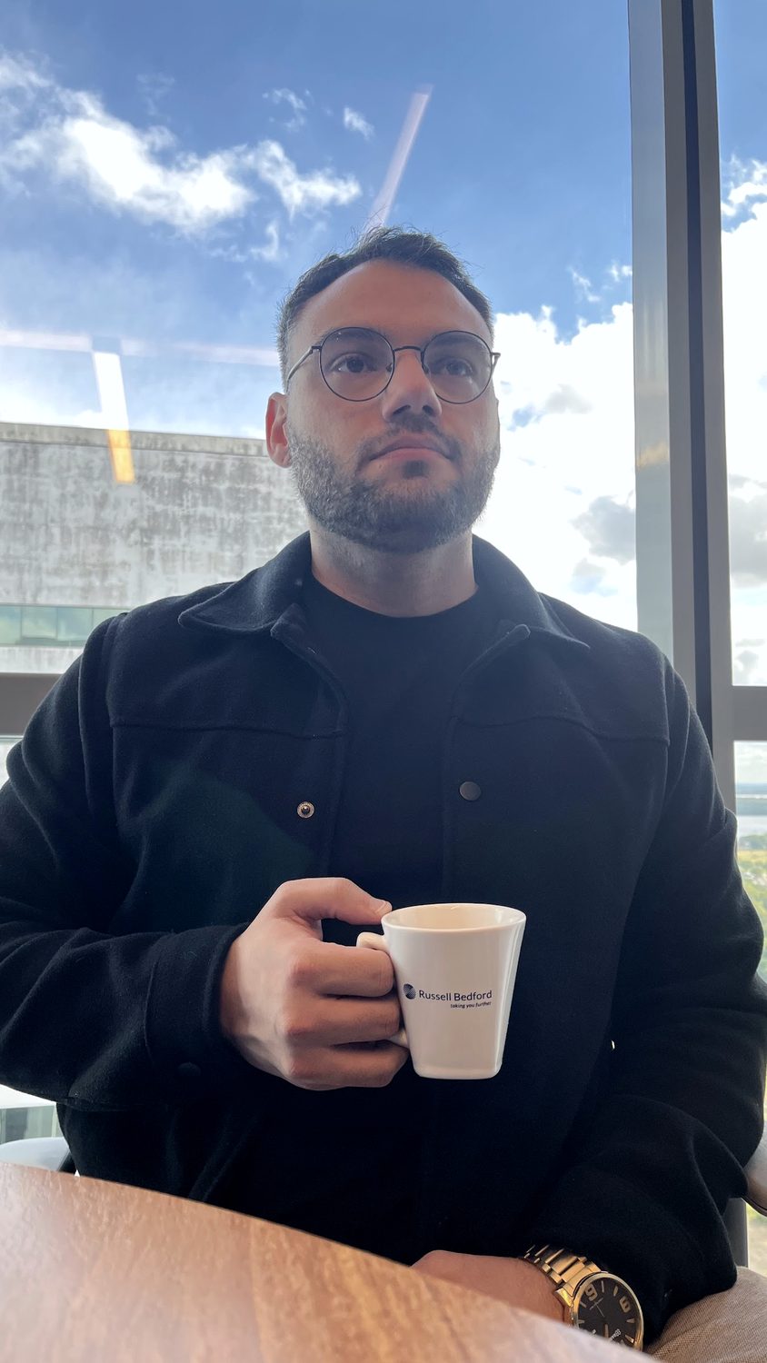 Matheus Orlando à mesa, com uma xícara de café