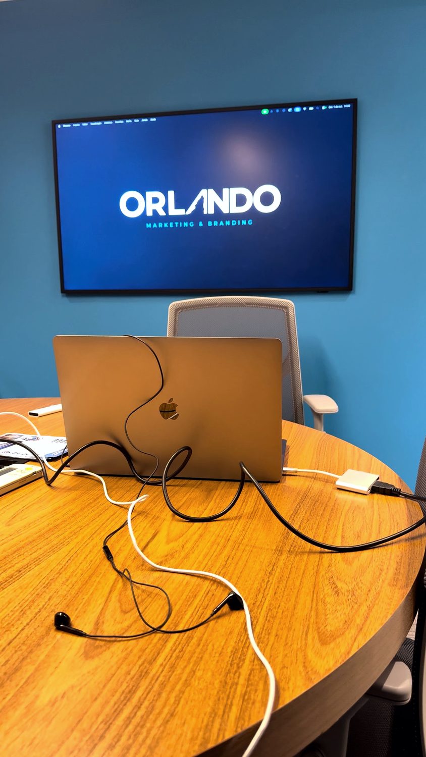 Sala de reunião com a marca ORLANDO exibida na tela