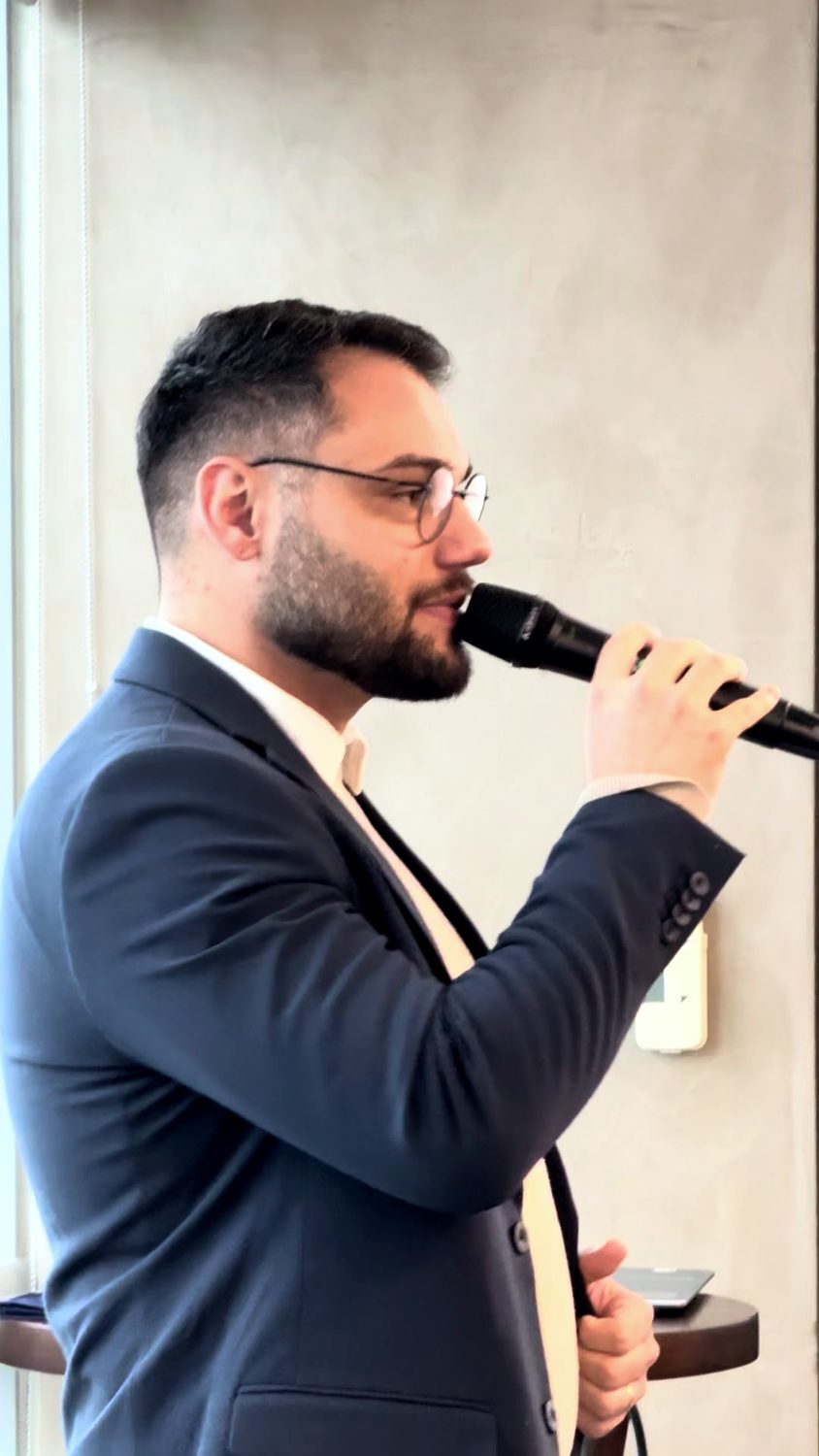 Matheus Orlando de perfil, falando ao microfone